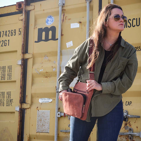 model with Vintage distressed buffalo leather concealed carry crossbody purse with adjustable slash-resistant strap, left and right-handed access, and a secure gun compartment designed for fast draw. Includes holster and fits compact handguns like S&W Shield, Ruger LCP, and Glock 42.