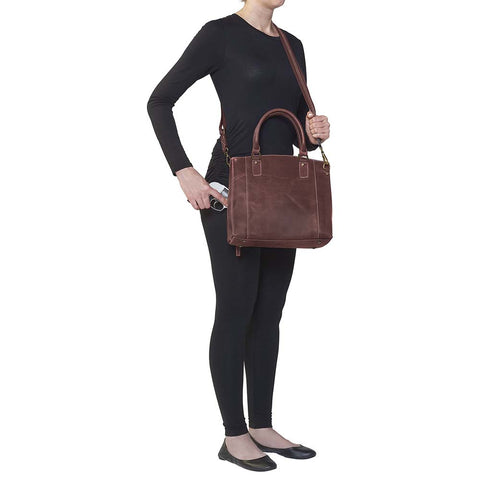 Bold distressed red full grain buffalo leather town tote with concealed carry functionality. Soft yet rugged vintage leather develops unique patina with everyday wear. Slash-resistant adjustable crossbody strap with padded gun compartment protects against imprinting. Designed for ambidextrous draw, multiple organizational pockets including secure zipper compartments. Includes Mernickle holster tested for compact and subcompact pistols. Perfect for confident, stylish concealed carry.