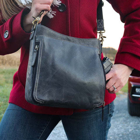 Gray distressed leather crossbody concealed carry bag with RFID-blocking card storage, vertical top-draw gun access, supports left/right-handed draw, secure fit for compact handguns, anti-slash strap included